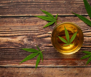 a glass of hemp tea with hemp leaves put on wooden floor
